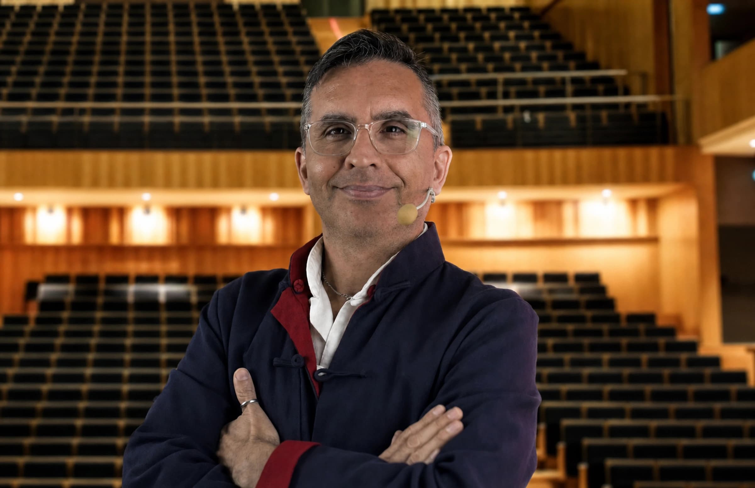 Retrato profesional de Diego Minevitz en un auditorio.